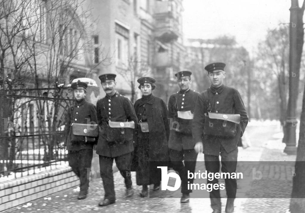 Postwoman with her male colleagues, 1916 (b/w photo)