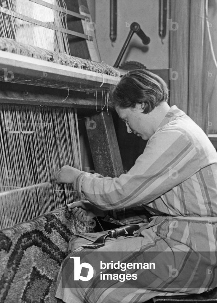 Training on the carpet knotting machine, 1931 (b/w photo)