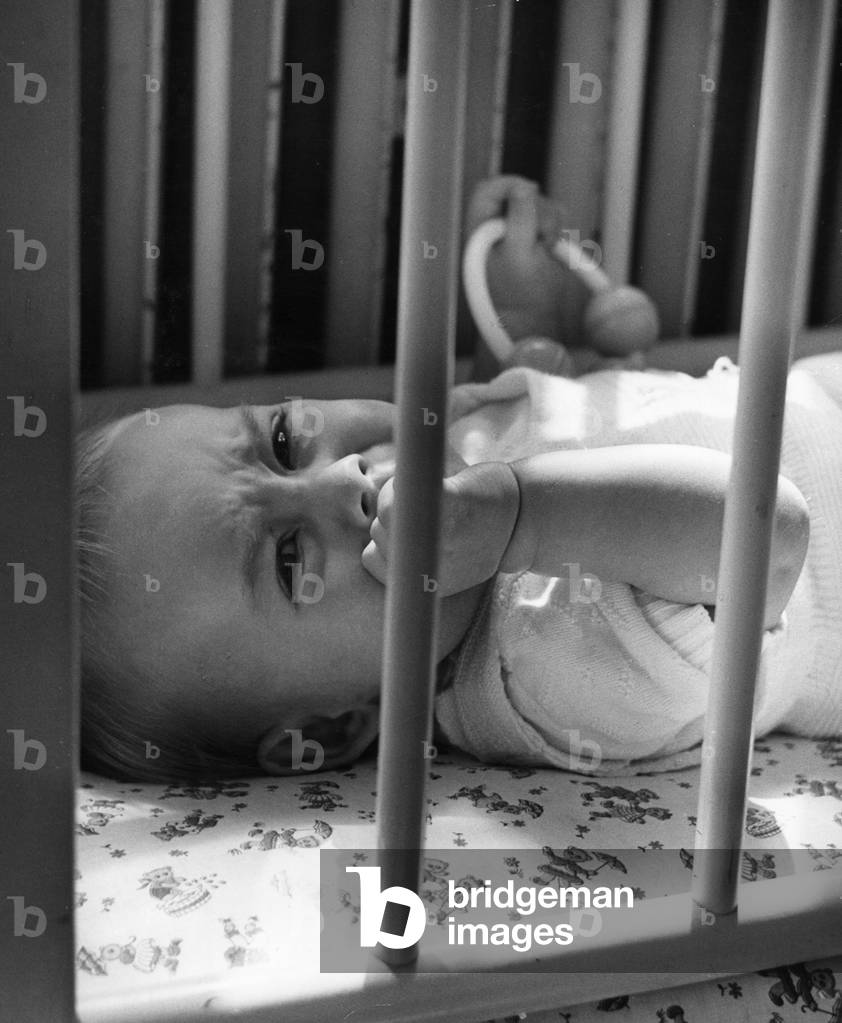 Baby in a crib (b/w photo)
