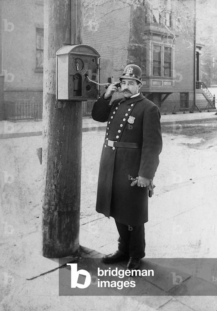 Police officer at a telephone pillar, 1903 (b/w photo)