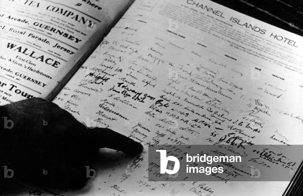 A guestbook for a hotel in the Channel Islands showing a change from English to German visitors, July 1940 (b/w photo)