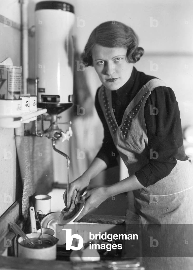 A housewife washes the dishes, 1936 (b/w photo)
