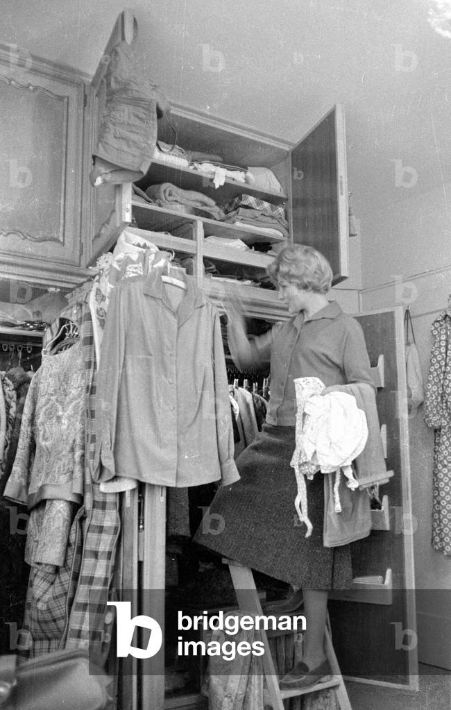 Heidi Bruehl in front of her wardrobe, 1959 (b/w photo)