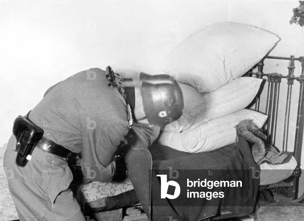 German policeman on the Eastern front searching a house, 1942 (b/w photo)