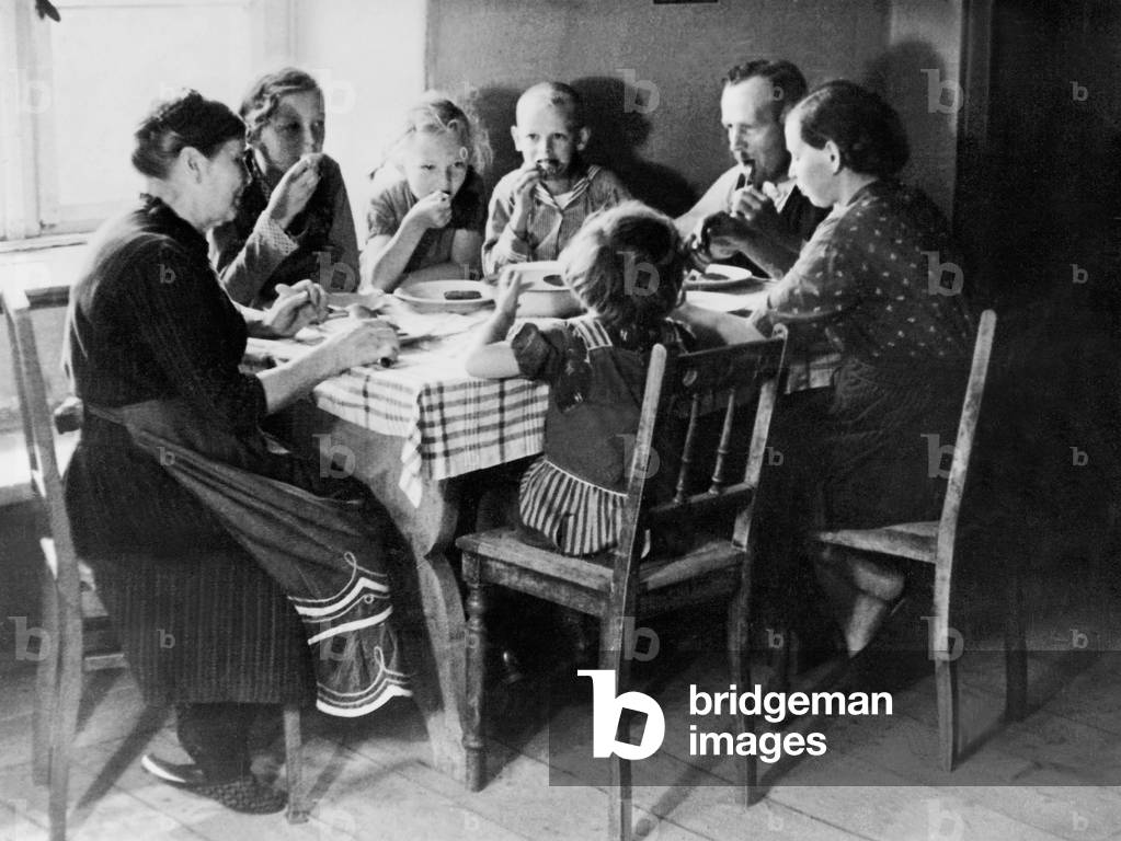 A farmer's family eating lunch, 1935 (b/w photo)