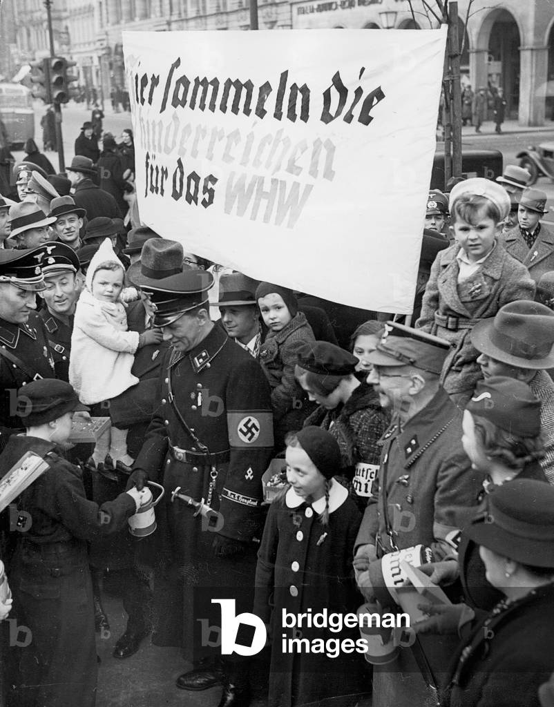 Member of the 'Reich League for Large Families' collect for the Winter Relief Program, 1938 (b/w photo)