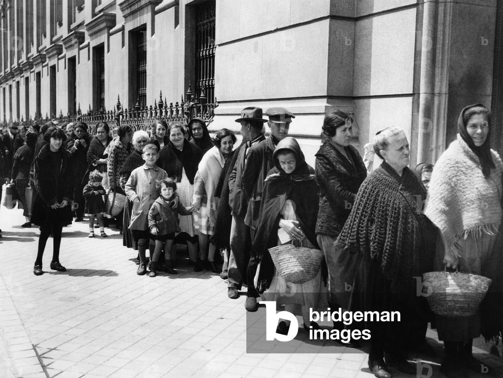 Farmers are waiting in front a bread counter in Madrid, 1930 (b/w photo)