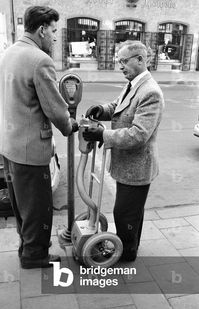 Parking meters are being emptied in the center of Munich, 1959 (b/w photo)