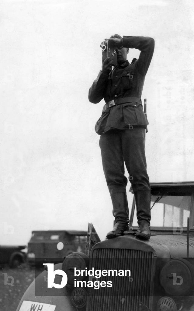 PK man filming on a car in a standing position, 1940
