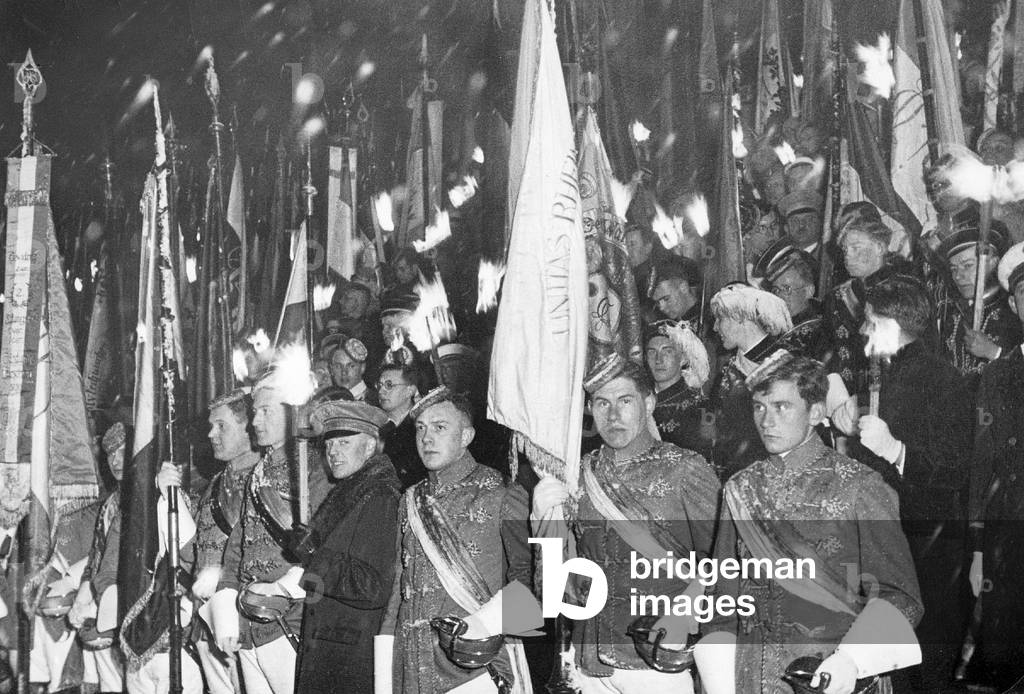 Students belonging to a dueling society at a torchlight procession, 1933 (b/w photo)