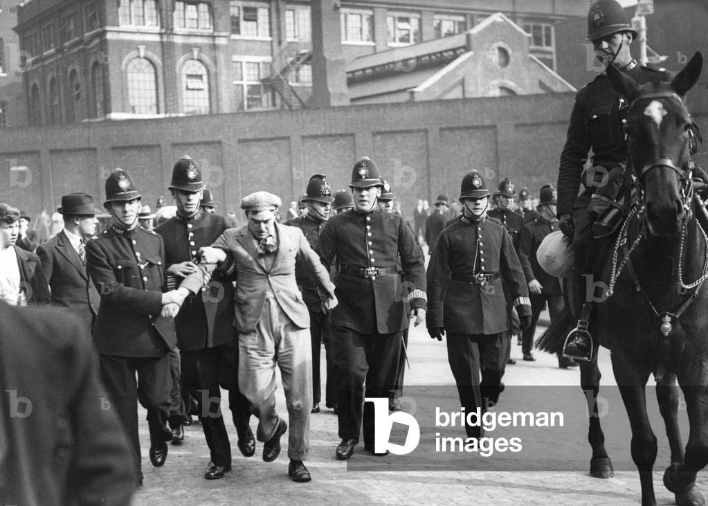 Policemen lead a demonstrator away in London, 1936 (b/w photo)