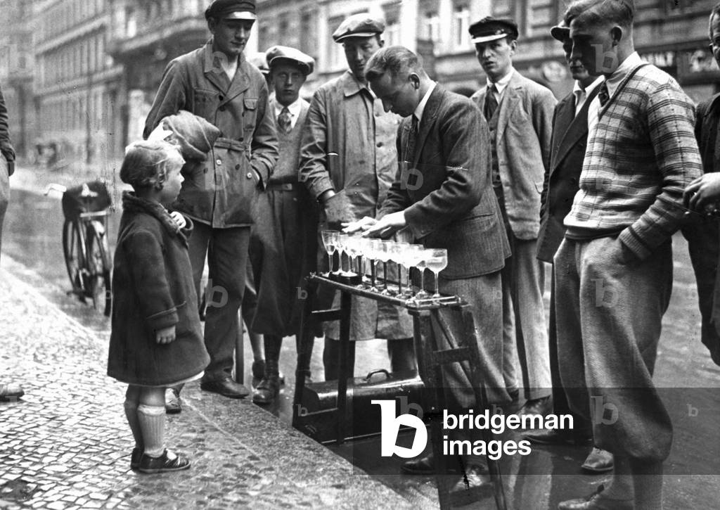 An unemployed person makes music with wine glasses in Berlin, 1932