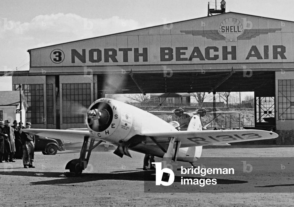 Plane in front of a hangar on the North Beach Airport, 1937 (b/w photo)