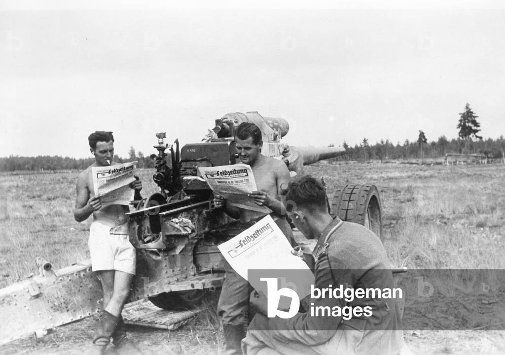 German gun crew reading the newspaper, 1941 (b/w photo)