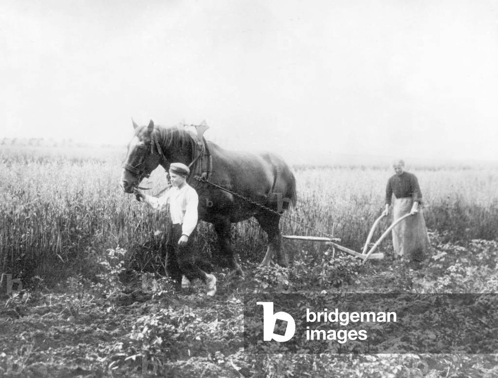 Woman and boy at field work, 1917 (b/w photo)