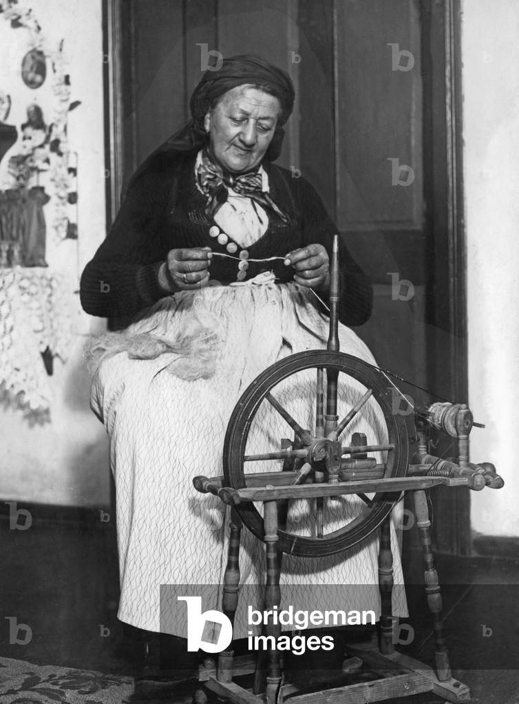 Country woman at the spinning wheel