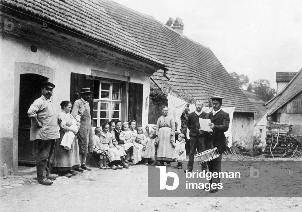 Town crier in the midst of a peasant family (b/w photo)