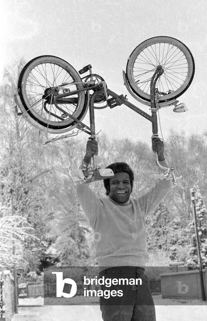 Roberto Blanco with bike in the snow, 1971 (b/w photo)