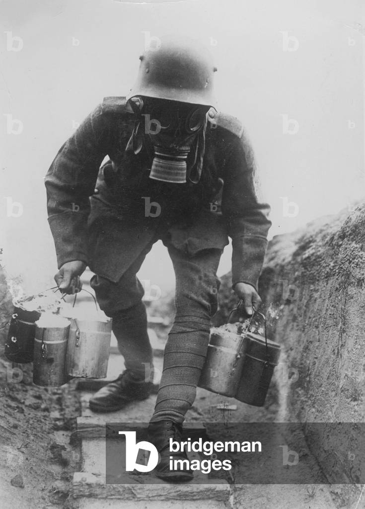 German soldier with gas mask carries food to a shelter, 1914-1918 (b/w photo)