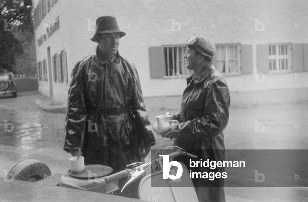 Vespa scooterists in the rain (b/w photo)