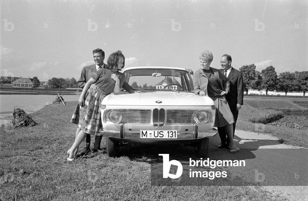 Men and women posing with a BMW 1800, 1963 (b/w photo)