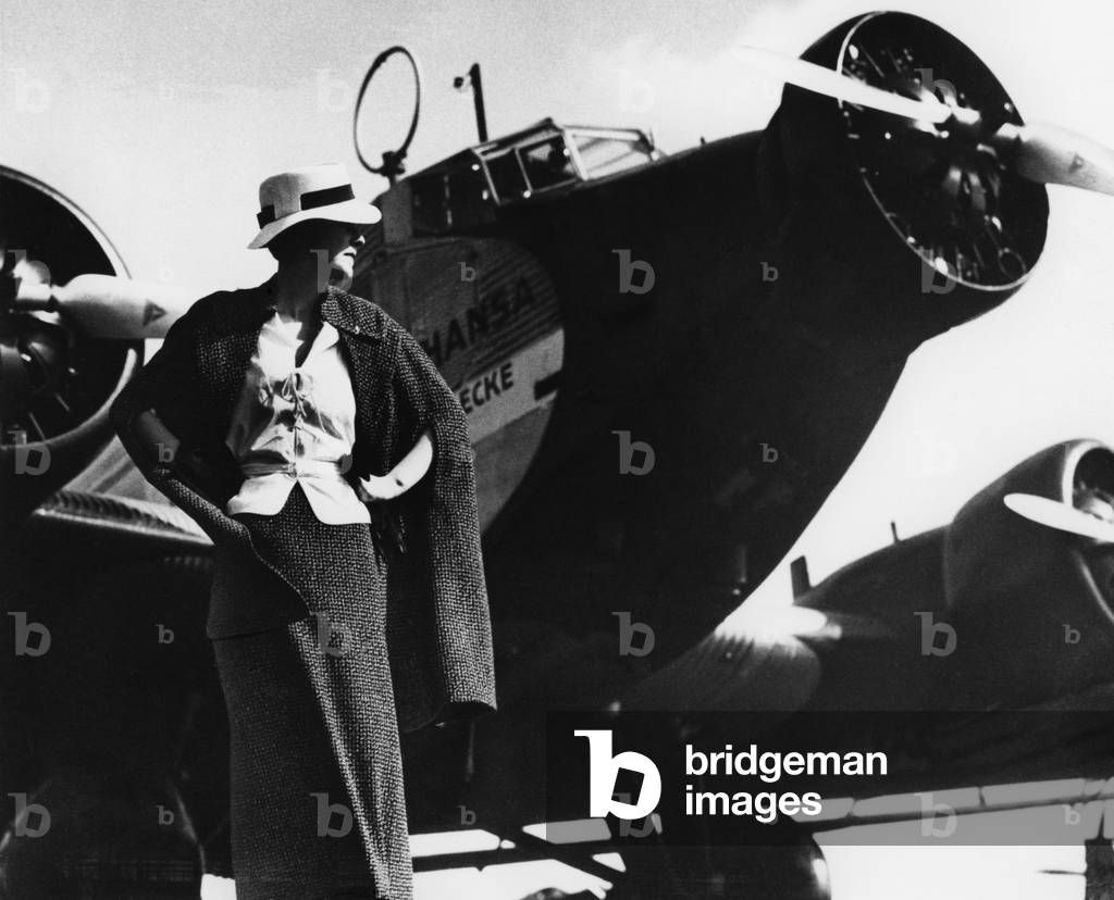 Model in front of an airplane, 1935 (b/w photo)