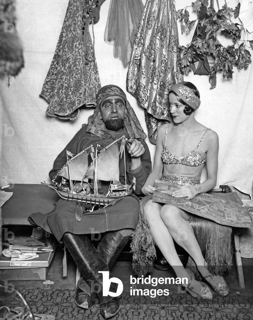 Actors in costume with a model boat, 1927 (b/w photo)