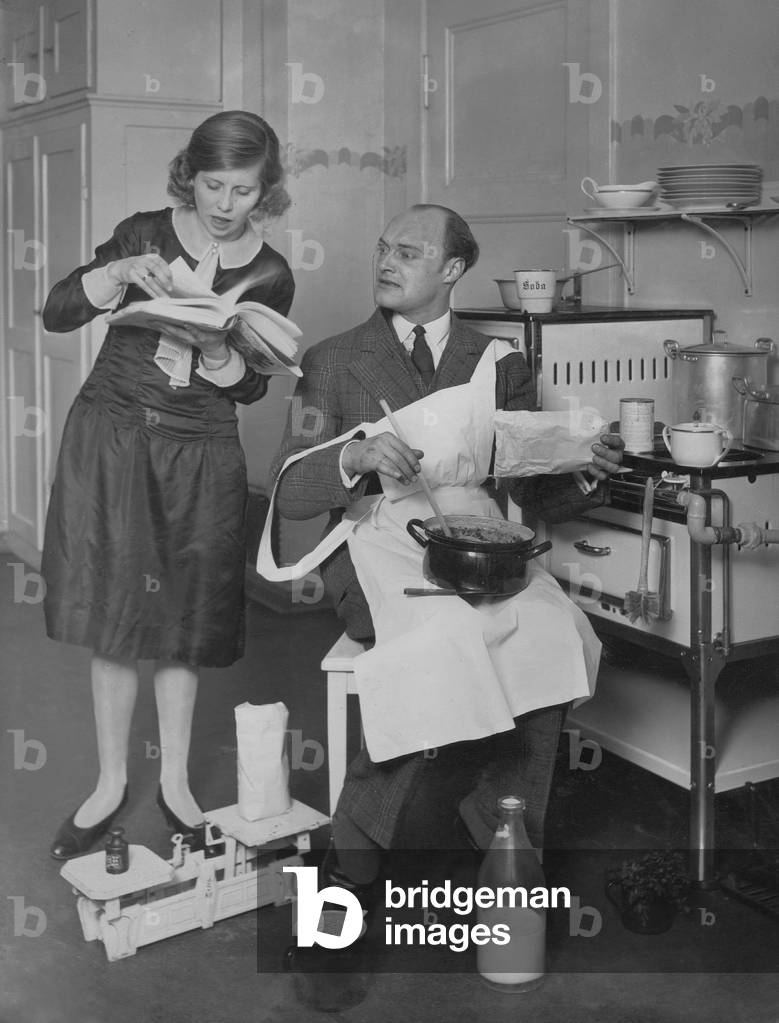 Husband and wife cooking, 1927 (b/w photo)