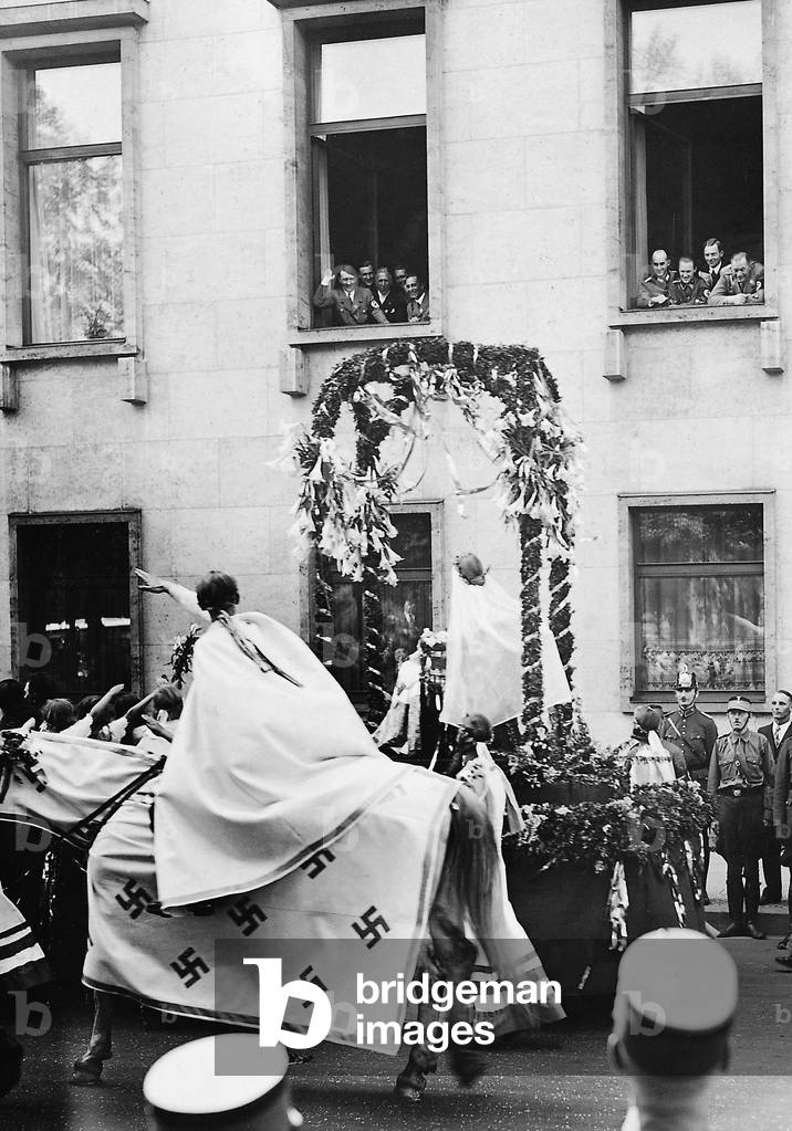 Adolf Hitler at the window during a pageant for the First of May, 1934 (b/w photo)