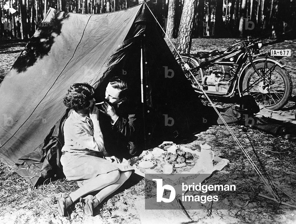 Young couple in front of a tent (b/w photo)