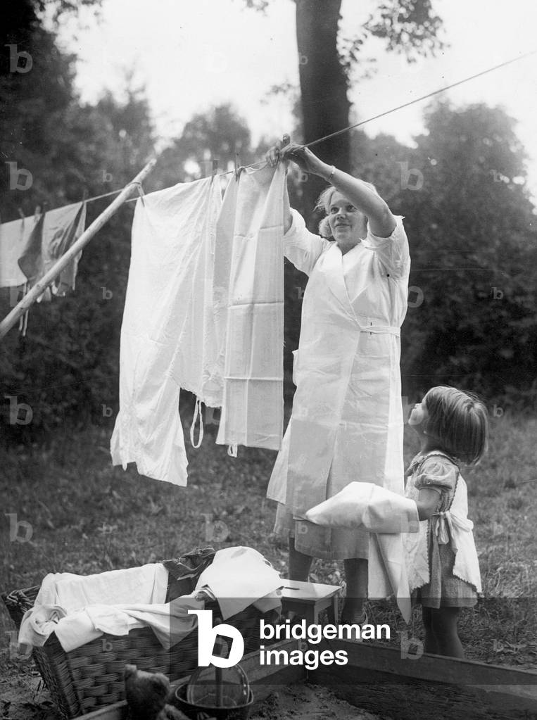 Housewife hangs up laundry (b/w photo)