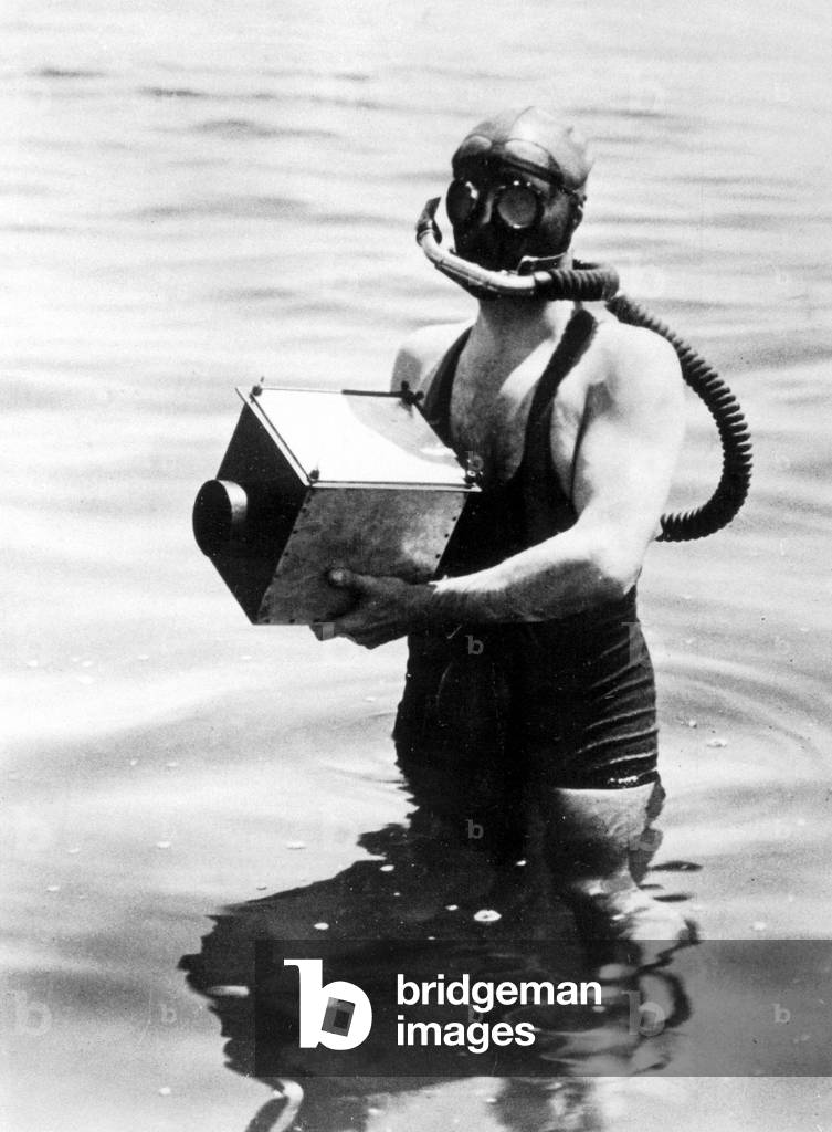 Diver with underwater camera (b/w photo)