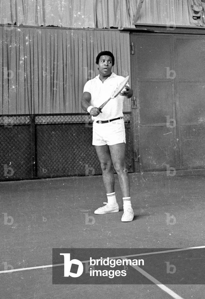 Roberto Blanco playing tennis, 1970 (b/w photo)