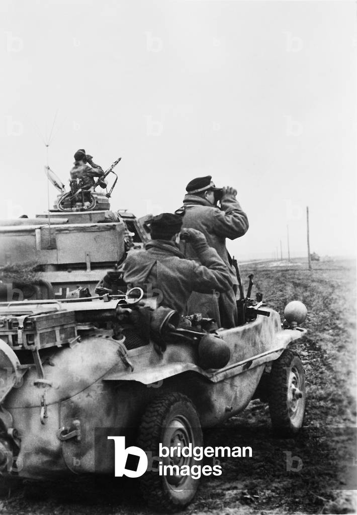 German soldier observing combat on the Eastern front, 1943 (b/w photo)