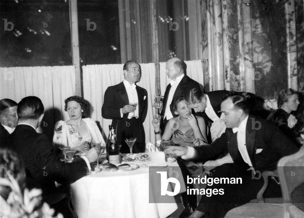 Heinz Ruehmann with Heli Finkenzeller and Leni Mahrenbach at a reception, 1937 (b/w photo)