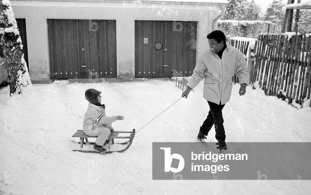 Roberto Blanco with sledge, 1970 (b/w photo)