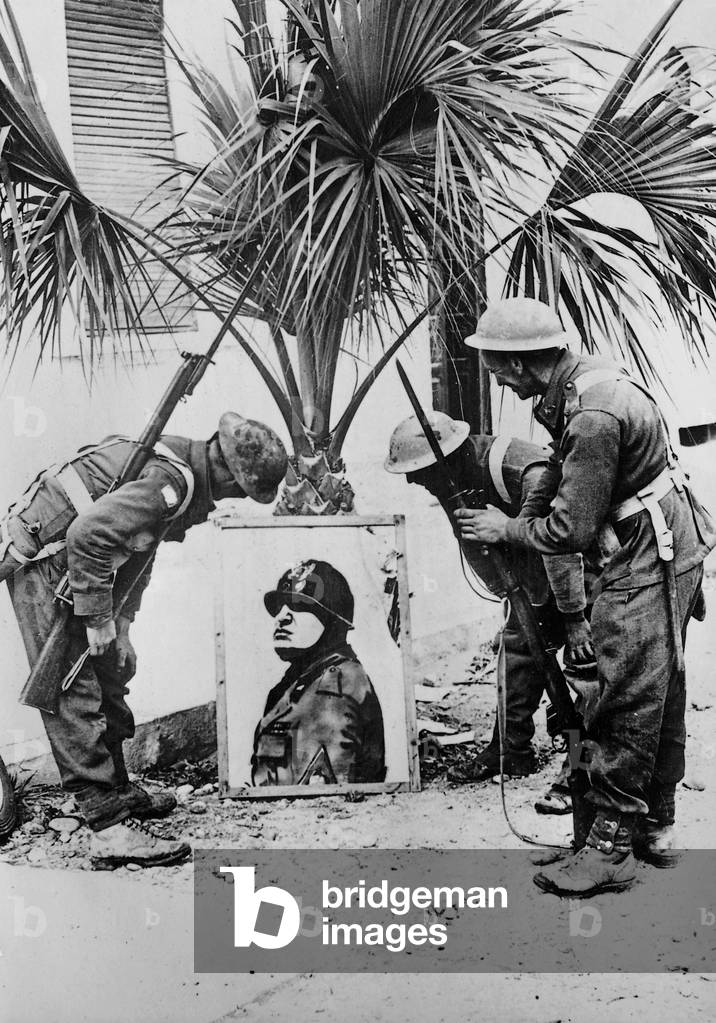 British soldiers examining a portrait of Mussolini, following the capture of the Italian military fortification at Bardia, Libya, 1941 (b/w photo)