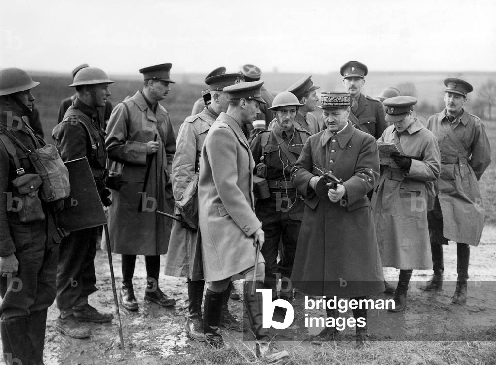 King George VI of England watches general handling and explaining a sub-machine gun wich is used by british partrols, december 1939.
