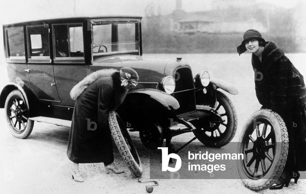 Women changing wheel on a Fiat 501 car (produced in 1919-1926)