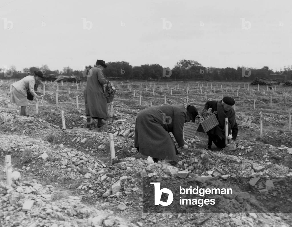 French ladies from villages around Normandy in France near Omaha Beach (Colleville sur Mer) place flowers on the graves of American soldiers who gave their lives on the beaches and in front line assaults on the continent, june 20, 1944, photo NARA