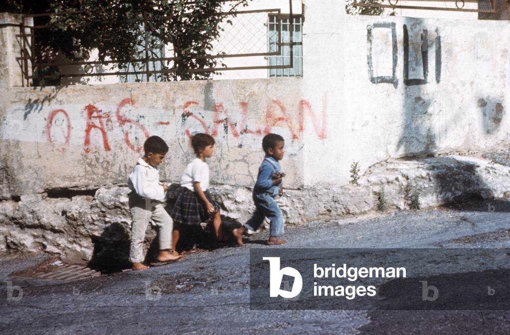 In Algiers, june 1962 : children in the streets and graffittis for OAS (terrorist organization opposed to Algerian independence) and general Salan \r
