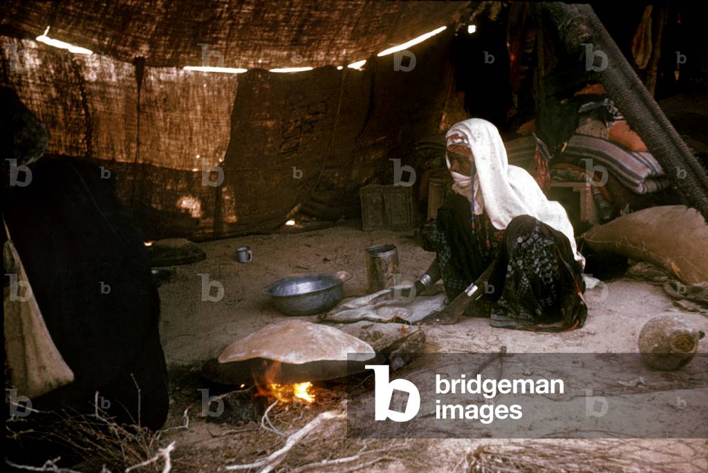 Bedouin woman in BeerSheeba in Palestine making a meal under a tent