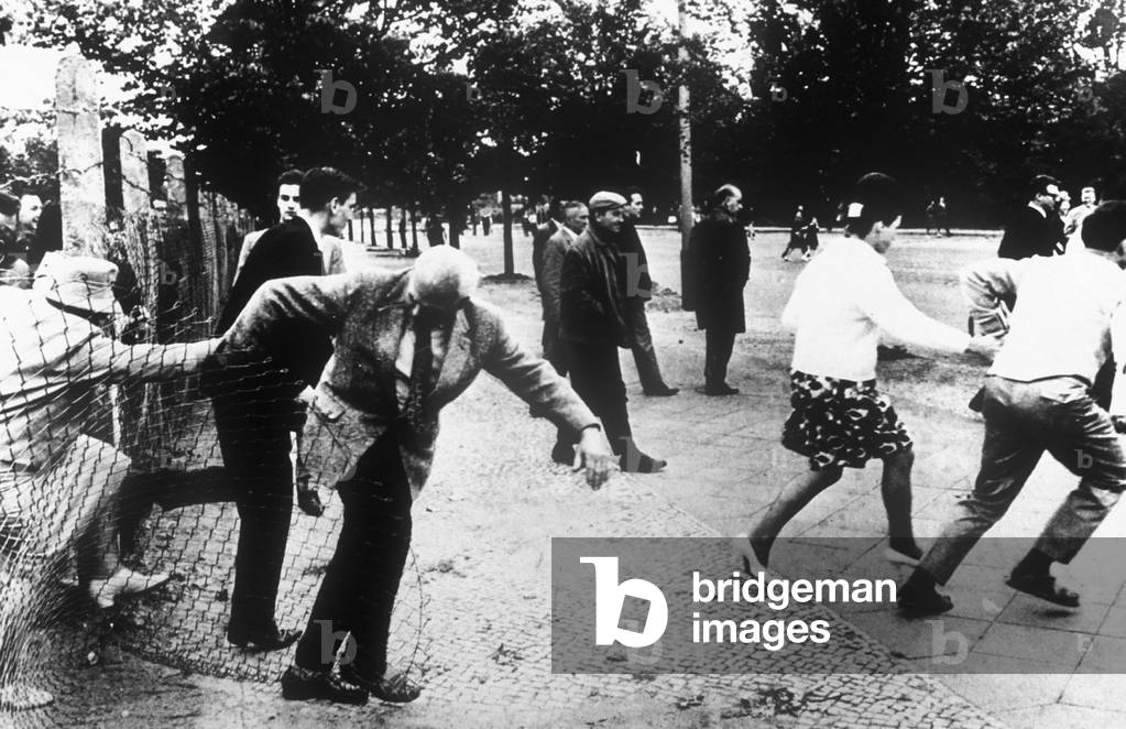 People of Berlin passing through a wire netting to reach other area of the town, 1961