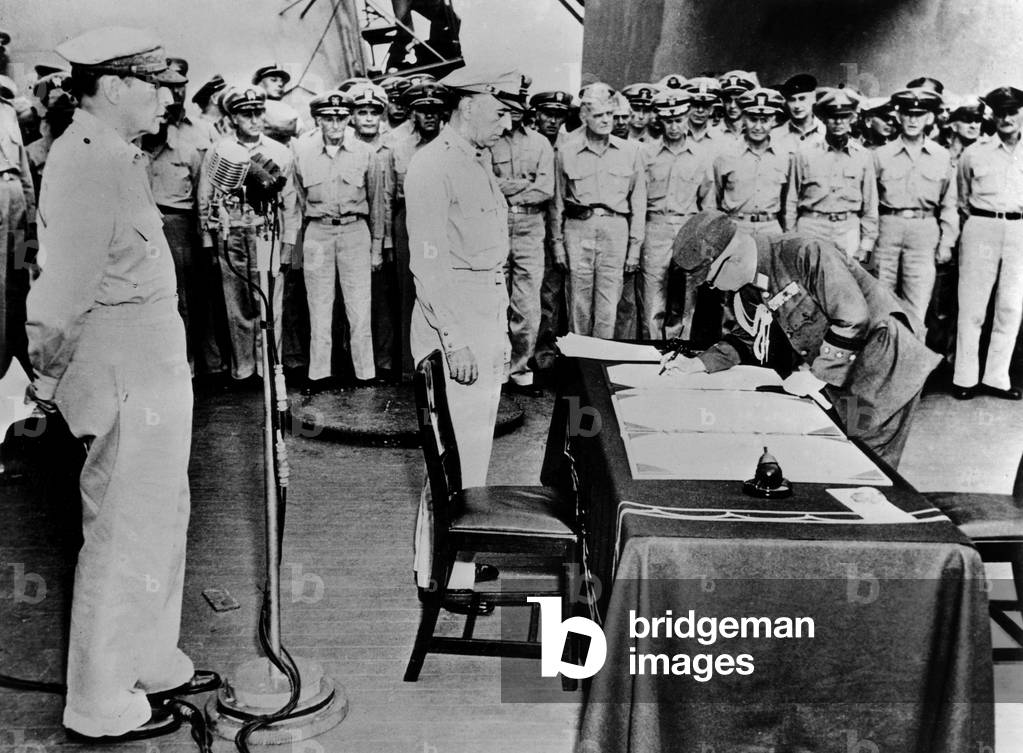 japanese general Yoshira Umeza signs on behalf of the Japanese Imperial General Headquarter during the surrender ceremony on the US battleship Missouri in Tokyo bay, september 2, 1945, on l is general Douglas MacArthur, c is US lt General Richard K. Sutherland (MacArthur's Chief of Staff), photo NARA