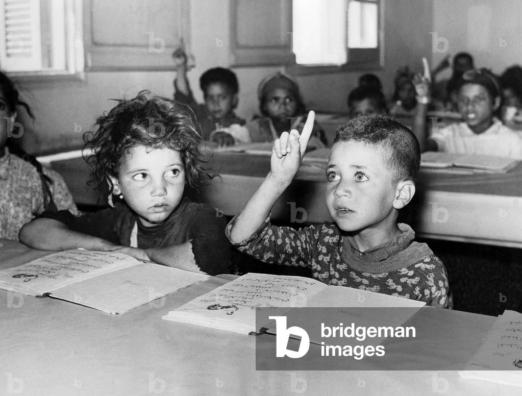 Children of Algerian soldiers who fought on the French side in the war of independence (Harkis) with their notebooks in arabic, before leaving to France, 1962