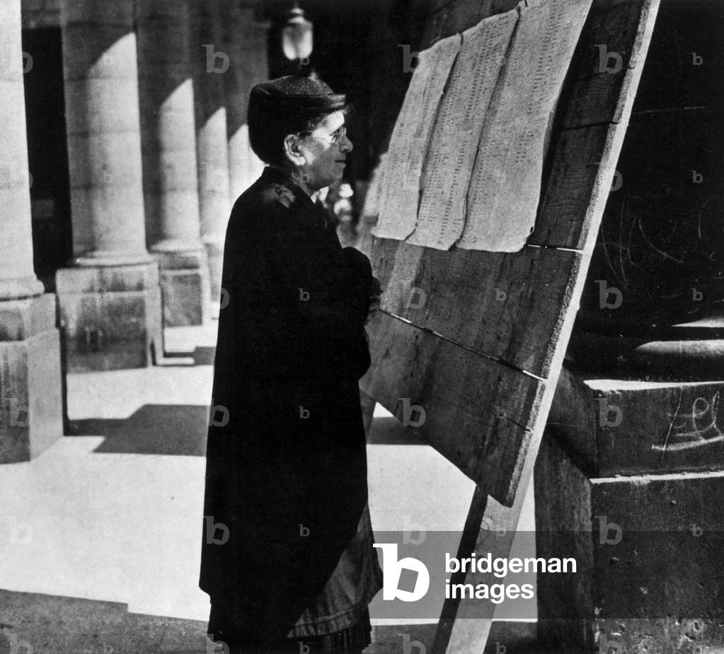 Woman reading list of prisoners during ww2, France