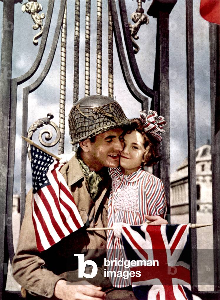 american soldier with French little girls on spring 1945 in front of the gates of Versailles castle : tenderness look makes up for the lack of common language , picture used for propaganda for the american liberators