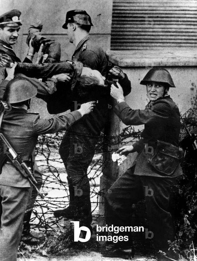 East German policemen evacuating body of Peter Fechter, 18 years old, he tried to getting over Berlin wall but was wounded and lost his blood during 50 minutes, august 17, 1962