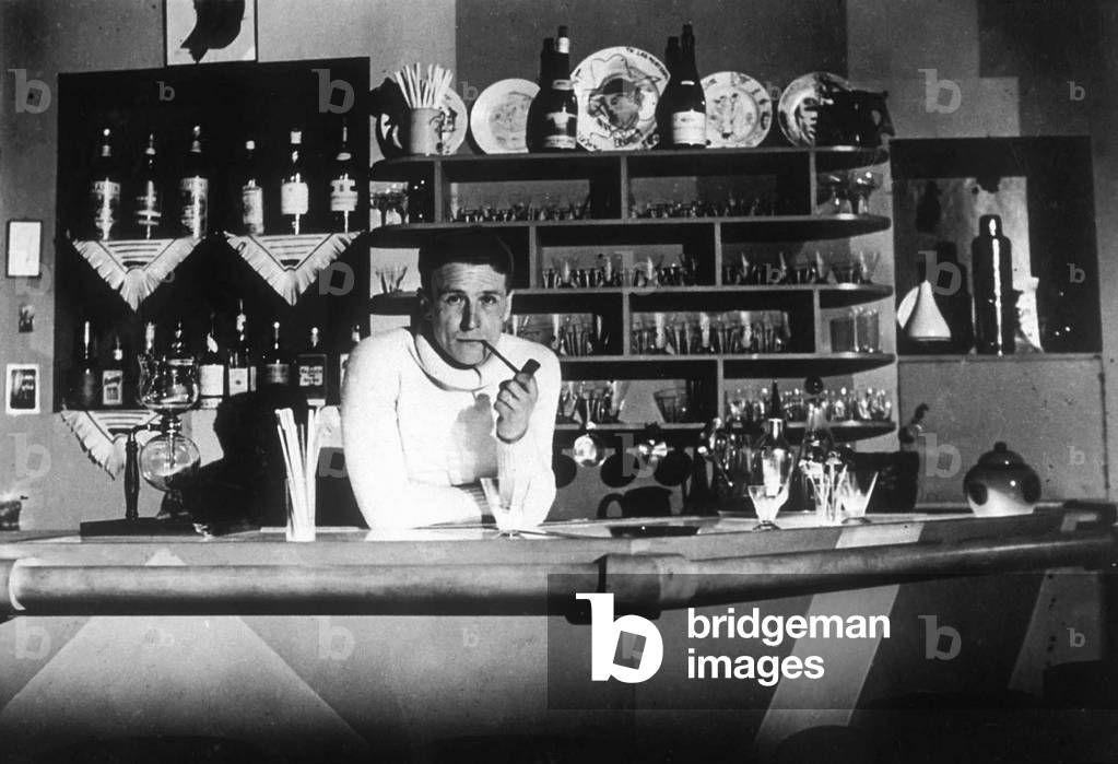 French novelist Georges Simenon (1903-1989) here around 1926 at the bar in his parisian apartment