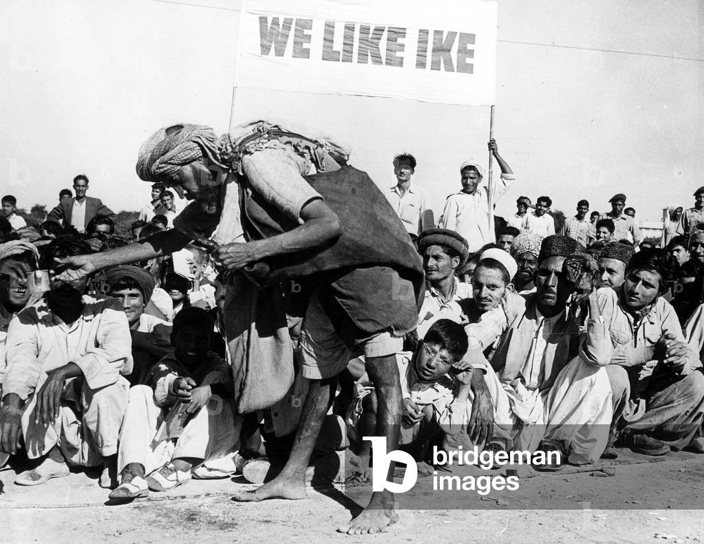 Water street vendor distributing warter to the crowd waiting for american president Dwight Ike Eisenhower in visit to Pakistan december 8, 1959
